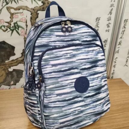 Kipling minimalist modern style fashionable blue and white striped backpack with plastic monkey accessories